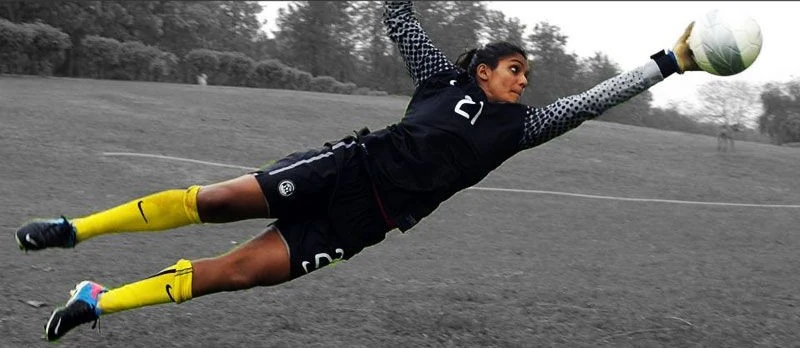 Aditi Chauhan diving full-stretch to make a goalkeeping save on a training pitch
