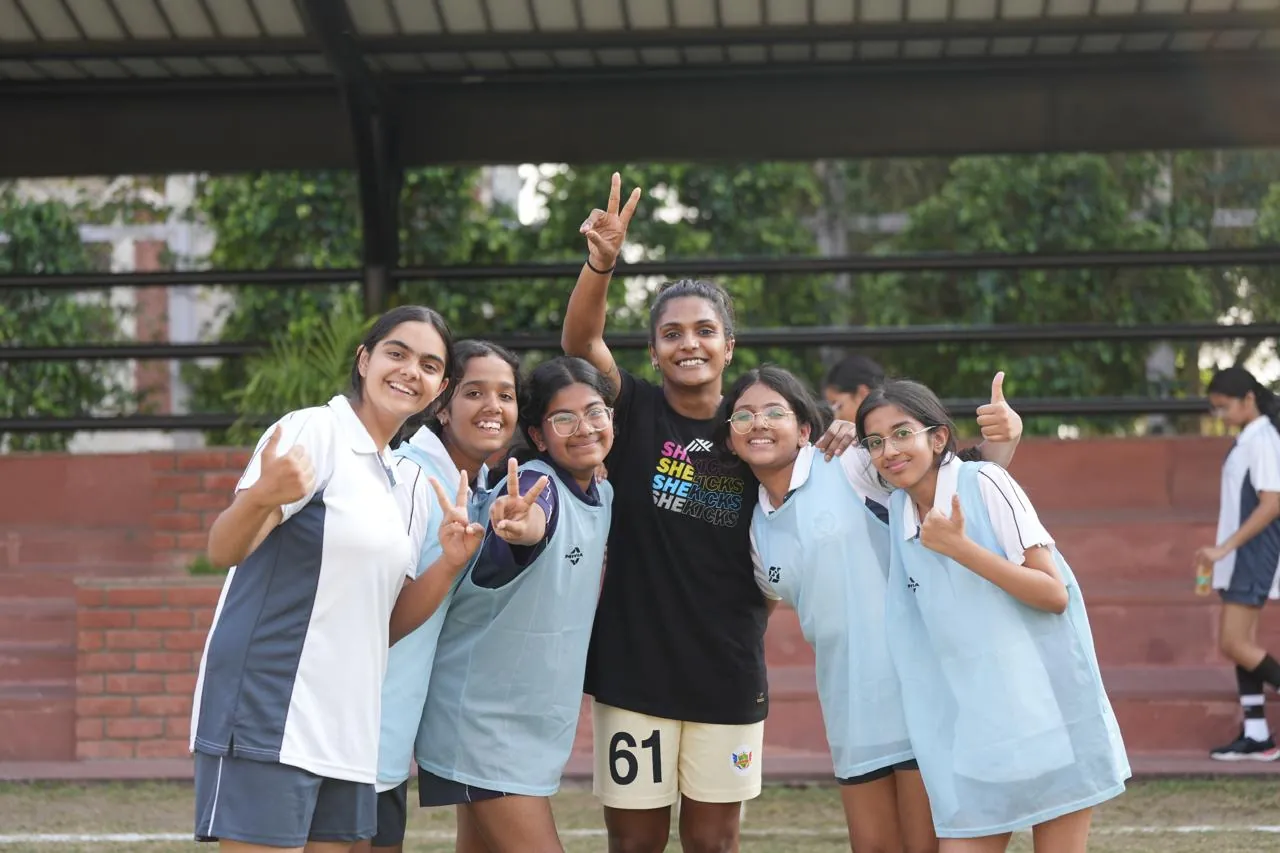 Aditi Chauhan celebrating with a group of schoolgirls in bibs after a She Kicks session