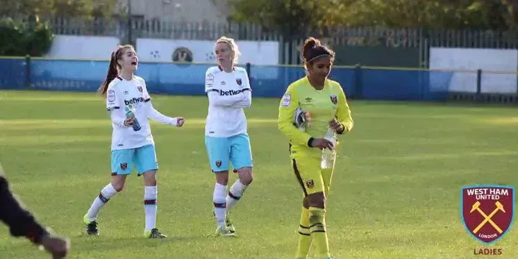Aditi Chauhan in her yellow West Ham United goalkeeper kit on the pitch.