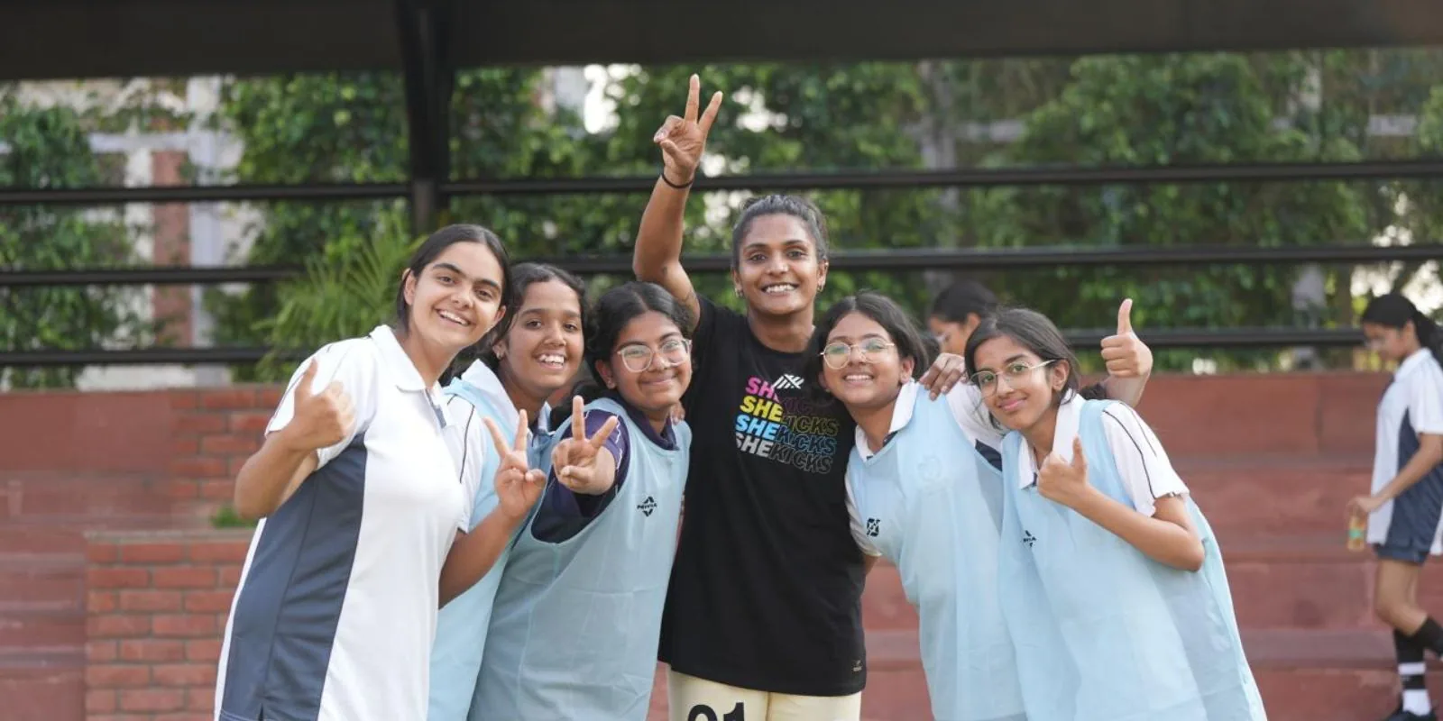 Aditi Chauhan posing with five schoolgirls in bibs celebrating after a session