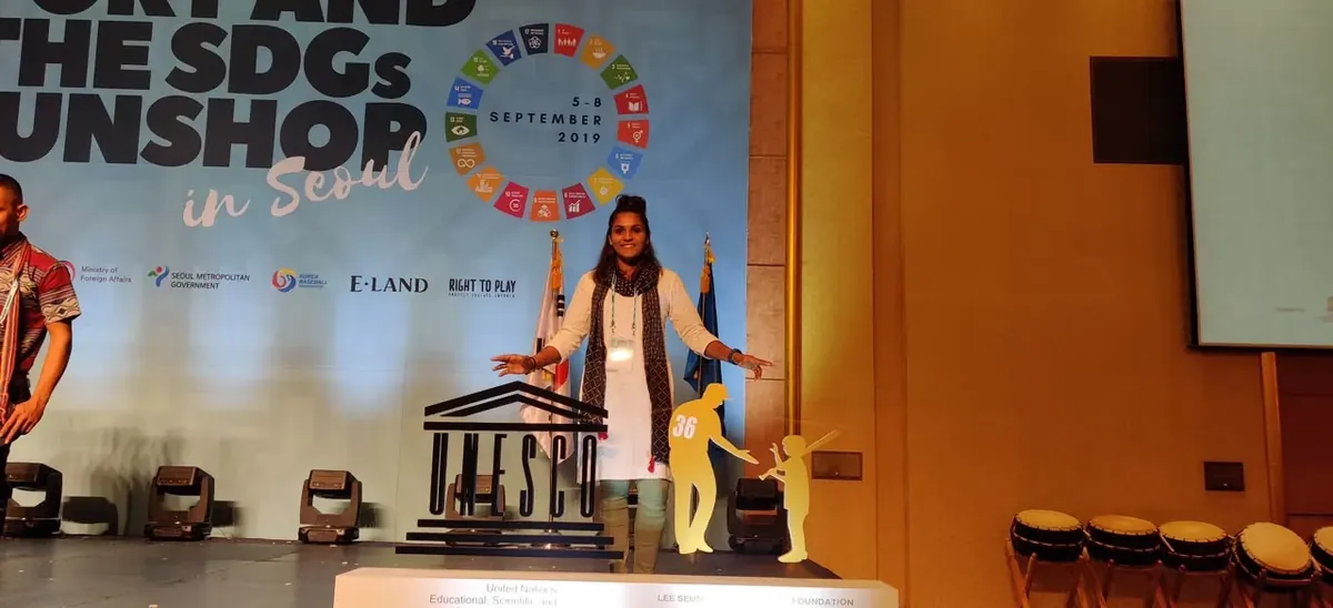 Aditi Chauhan speaking on stage at a UNESCO event in Seoul.
