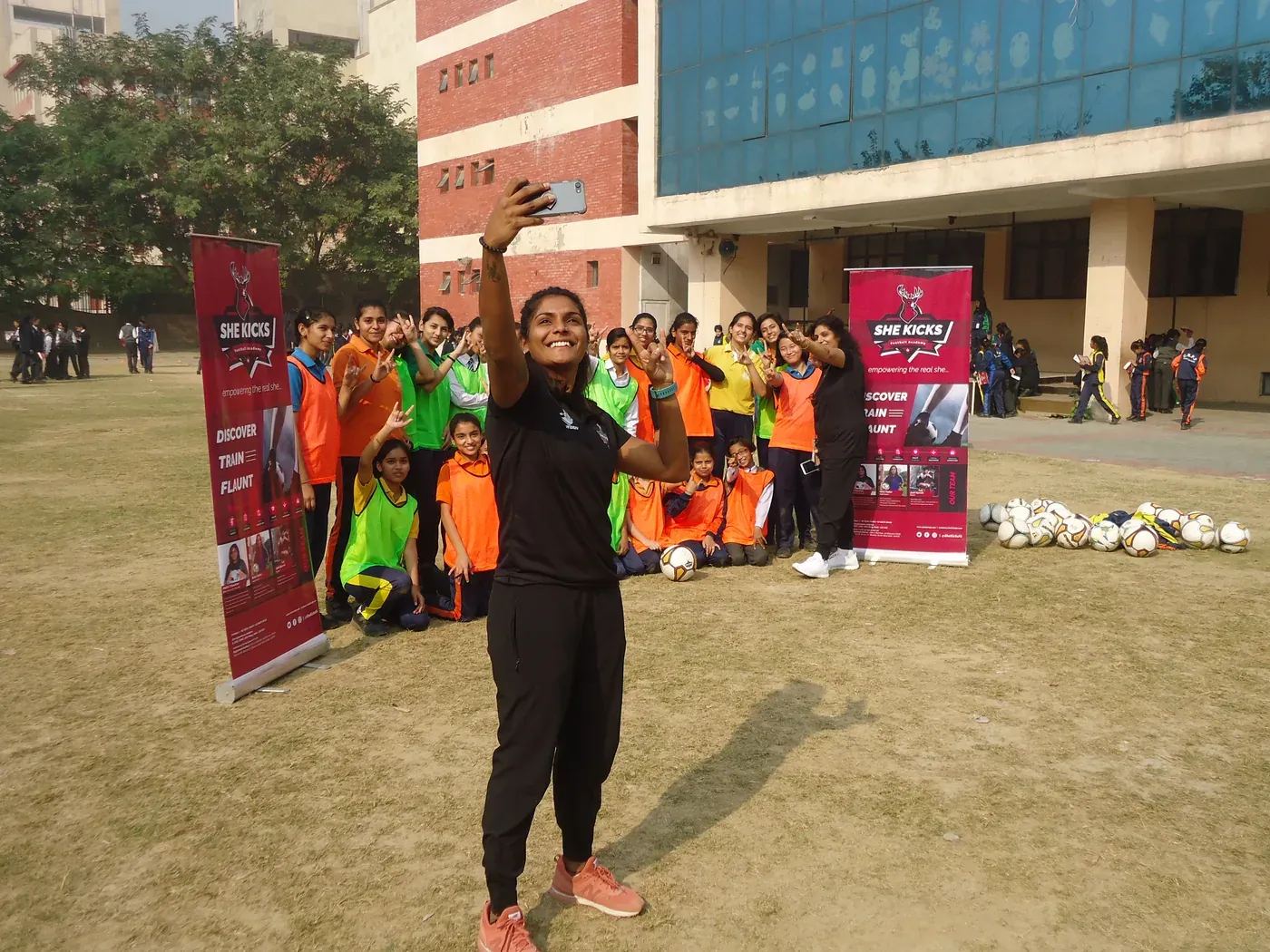 Aditi Chauhan taking a selfie with girls in bibs at a She Kicks football academy session