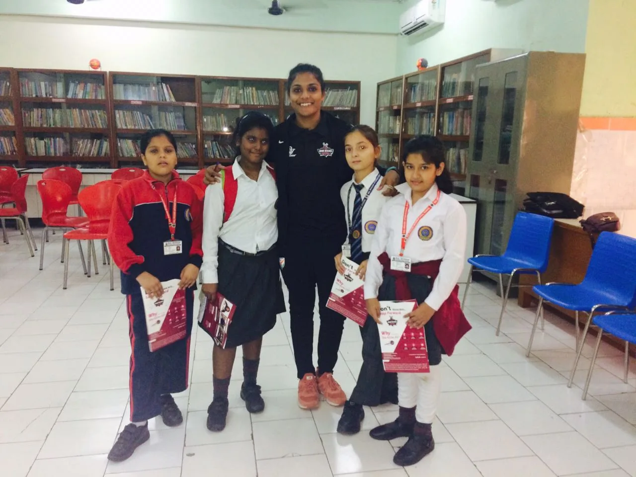 Aditi Chauhan with schoolgirls holding She Kicks flyers during a school outreach visit