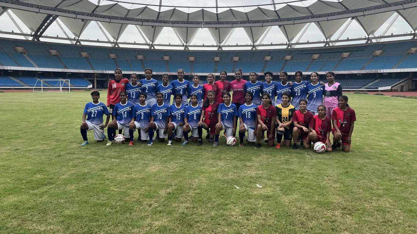 She Kicks club squad lined up together on the pitch at a stadium